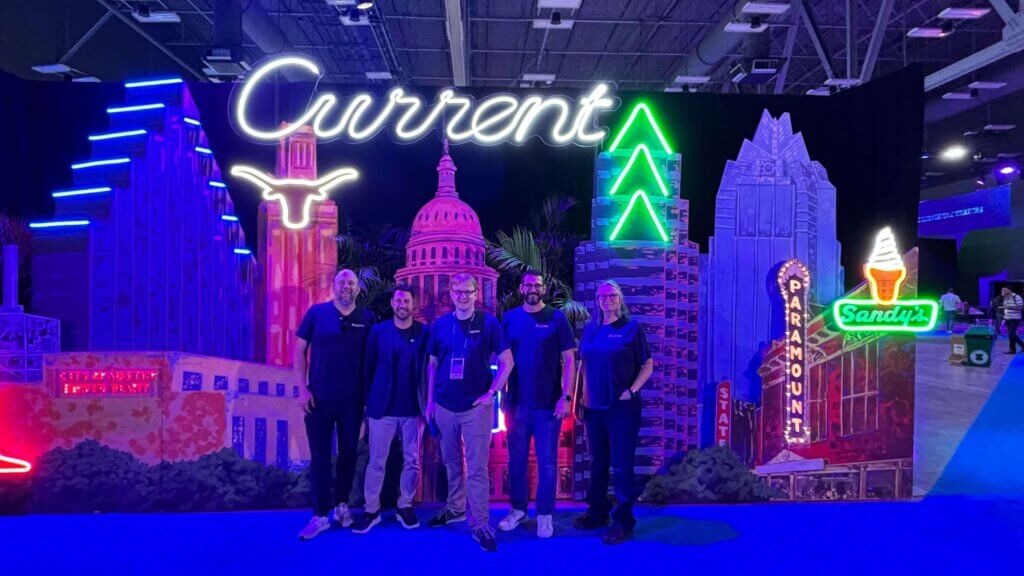 Foreground is five people with Ryan Wright, CTO of thatDot at center. Current background with Austin, Texas landmarks.